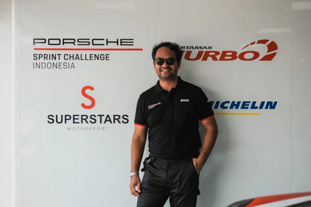 Bagoes Hermanto in front of a Porsche Sprint Challenge Indonesia and Superstars Motorsport backdrop